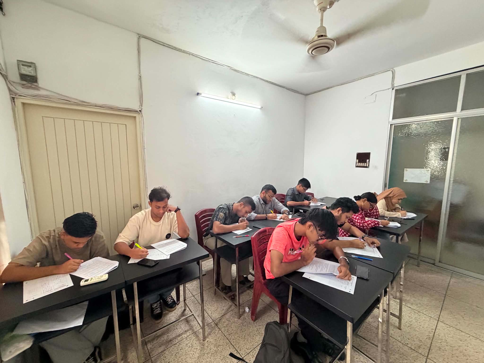 Students taking an offline mock test at desks in a classroom